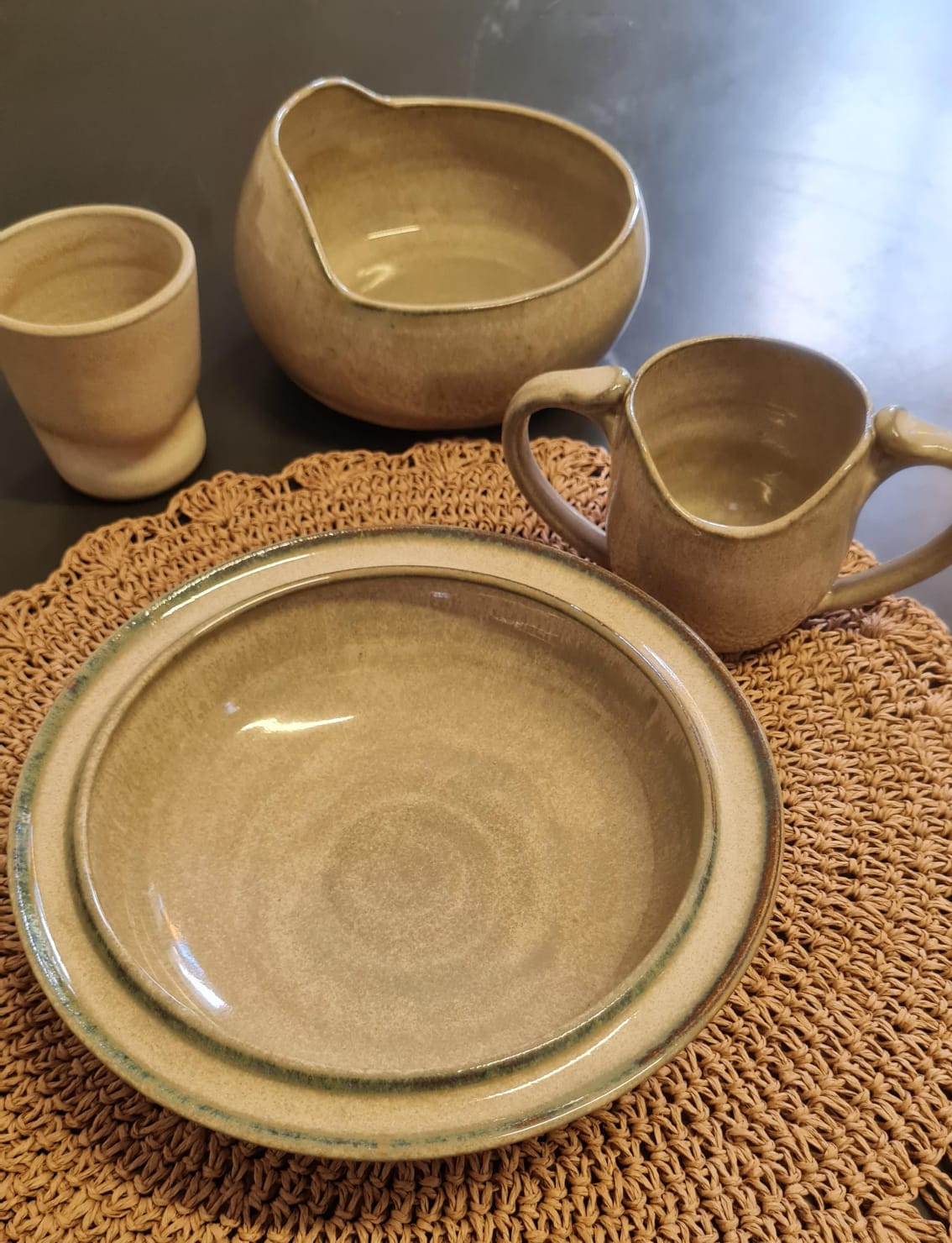 Peças adaptadas em tom areia dispostas sobre jogo americano de fibra natural